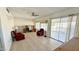 Bright living room featuring tile flooring, a ceiling fan, a sliding glass door, and comfortable seating at 10450 W Sutters Gold Ln, Sun City, AZ 85351