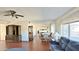 Open living room featuring hardwood floors, a ceiling fan, large windows and comfortable seating at 10450 W Sutters Gold Ln, Sun City, AZ 85351