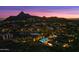 Aerial view of a luxury desert home with a pool and a mountain backdrop at dusk at 10585 E Crescent Moon Dr # 44, Scottsdale, AZ 85262