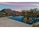 A sparkling pool features integrated lounge chairs with views of the surrounding mountains at 10585 E Crescent Moon Dr # 44, Scottsdale, AZ 85262