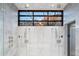 Stylish shower showcasing dual showerheads, marble tile, and mountain views through the window at 10585 E Crescent Moon Dr # 44, Scottsdale, AZ 85262