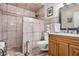 Bathroom featuring stone style shower with a wood cabinet sink at 10718 W Welk Dr, Sun City, AZ 85373