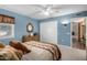 Comfortable bedroom with blue walls, white closet doors, and a dresser under a decorative mirror at 10718 W Welk Dr, Sun City, AZ 85373