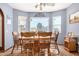 Cozy dining room featuring wood-look floors, a ceiling fan and natural light from the windows at 10718 W Welk Dr, Sun City, AZ 85373