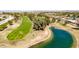 Aerial view of a golf course highlighting the green fairways, water features, and mature trees at 10718 W Welk Dr, Sun City, AZ 85373