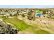 Beautiful aerial view of the golf course showcasing the lush green, sand traps, trees, and water features at 10718 W Welk Dr, Sun City, AZ 85373