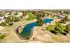 Scenic aerial view of the golf course, featuring a sparkling pond, manicured greens, and mature trees at 10718 W Welk Dr, Sun City, AZ 85373