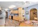 Efficient kitchen featuring wood cabinets, light-colored walls, and an adjacent dining area at 10718 W Welk Dr, Sun City, AZ 85373