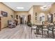 Inviting living room featuring neutral walls, wood-look flooring, a skylight, and a formal dining area at 10718 W Welk Dr, Sun City, AZ 85373