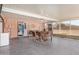 Enclosed patio with tile floor, a ceiling fan, and dining table set, adjacent to the back yard at 10718 W Welk Dr, Sun City, AZ 85373