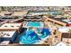 Aerial view of the community pool with a lazy river, lap pool, and many lounge chairs for residents to enjoy at 10718 W Welk Dr, Sun City, AZ 85373