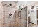 Shower with stone-style shower surround with a corner niche and wood colored cabinet at 10718 W Welk Dr, Sun City, AZ 85373