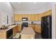 Well-lit kitchen features wooden cabinets, an island, and modern black appliances at 1113 E Devon Dr, Gilbert, AZ 85296