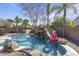 Backyard pool features a rock waterfall, slide, and clear blue water, perfect for relaxation at 1113 E Devon Dr, Gilbert, AZ 85296