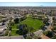 A large green field and mature trees nestled in a residential neighborhood with mountain views at 1233 E Azure Sea Ln, Gilbert, AZ 85234