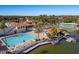 A long pool sits next to a Personal-made lake and a clubhouse in the background at 1233 E Azure Sea Ln, Gilbert, AZ 85234