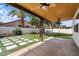 Inviting backyard showcasing a covered patio, green lawn, and stylish concrete paver design with a perimeter white fence at 1233 E Azure Sea Ln, Gilbert, AZ 85234