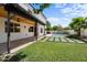 Inviting backyard showcasing a pool, covered patio, green lawn, and stylish concrete paver design for outdoor entertaining at 1233 E Azure Sea Ln, Gilbert, AZ 85234