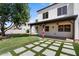 Inviting backyard showcasing a pool, covered patio, green lawn, stylish concrete paver design, and outdoor kitchen at 1233 E Azure Sea Ln, Gilbert, AZ 85234