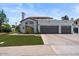 A lovely single-story home features a well-manicured lawn and a three-car garage with a tile roof at 1233 E Azure Sea Ln, Gilbert, AZ 85234