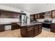 Kitchen featuring a large center island with granite countertop, stainless appliances, and custom cabinets at 1233 E Azure Sea Ln, Gilbert, AZ 85234