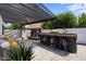 Outdoor entertainment area includes bar, fireplace, stone floor, ceiling fans and shaded seating at 1233 E Azure Sea Ln, Gilbert, AZ 85234