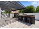 Covered patio features an outdoor kitchen with a built-in bar, seating, and a charming fireplace for entertaining at 1233 E Azure Sea Ln, Gilbert, AZ 85234