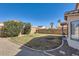 A view of the backyard with gravel, grass and a block wall at 13444 W Ocotillo Ln, Surprise, AZ 85374