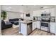 Kitchen featuring stainless steel appliances and a breakfast bar open to living room at 13444 W Ocotillo Ln, Surprise, AZ 85374