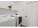 A clean laundry room with white appliances and shelves at 13444 W Ocotillo Ln, Surprise, AZ 85374