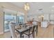 Bright dining room featuring modern lighting, sliding glass doors, and open floor plan to the kitchen and living area at 1356 E Penedes Ct, Gilbert, AZ 85298