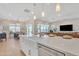 Open-concept kitchen with white countertops, island sink, and stainless steel appliances, seamlessly connecting to the dining and living areas at 1356 E Penedes Ct, Gilbert, AZ 85298