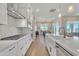 Spacious kitchen featuring white cabinetry, stainless steel appliances, tile backsplash and large island with sink and faucet at 1356 E Penedes Ct, Gilbert, AZ 85298