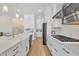 Modern kitchen with stainless steel appliances, white cabinetry, white marbled countertops, and wood-look tile flooring at 1356 E Penedes Ct, Gilbert, AZ 85298