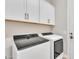 Bright laundry area with white cabinets, light walls, and stainless steel appliances at 1356 E Penedes Ct, Gilbert, AZ 85298