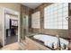 Elegant bathroom featuring a soaking tub, glass enclosed shower, and tile accent wall at 1412 E Jade Dr, Chandler, AZ 85286