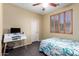 Well-lit bedroom with wood floors, a ceiling fan, and a desk with computer setup at 1412 E Jade Dr, Chandler, AZ 85286