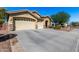 Charming single-story home featuring a three-car garage and desert landscaping under a bright blue sky at 1412 E Jade Dr, Chandler, AZ 85286