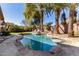 Backyard pool area features mature palm trees, a built-in bar table, and waterfalls at 1412 E Jade Dr, Chandler, AZ 85286