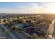 Aerial view of a community with tennis courts, a golf course, lush greenery, and well-maintained roads at 14257 W Harvard St, Goodyear, AZ 85395