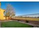 Manicured backyard with artificial turf, gravel landscaping, and a black metal fence with a view at 14257 W Harvard St, Goodyear, AZ 85395