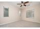 Spacious bedroom with neutral carpet, ceiling fan, and bright natural light from three windows at 14257 W Harvard St, Goodyear, AZ 85395