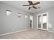 Neutral bedroom with gray walls, ceiling fan, access to a walk-in closet, and sliding door to a balcony at 14257 W Harvard St, Goodyear, AZ 85395