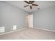 Bedroom featuring neutral carpet, gray walls, a ceiling fan and closet access at 14257 W Harvard St, Goodyear, AZ 85395