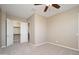 Spacious, carpeted bedroom with a ceiling fan, a view of the walk-in closet, and plenty of wall space at 14257 W Harvard St, Goodyear, AZ 85395