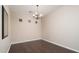 This empty dining room has wood floors and a modern chandelier at 14257 W Harvard St, Goodyear, AZ 85395