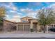 Charming home showcasing a two-car garage, desert landscaping, and a welcoming front patio at 14257 W Harvard St, Goodyear, AZ 85395