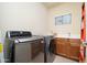 Bright laundry room equipped with modern washer, dryer, and utility sink at 14257 W Harvard St, Goodyear, AZ 85395