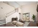 Bright living room featuring high ceilings, modern furniture, hardwood floors, and a staircase to the second floor at 14257 W Harvard St, Goodyear, AZ 85395