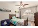 Comfortable bedroom with ceiling fan, wood floors, and natural light from shuttered window at 1506 E Gemini Dr, Tempe, AZ 85283